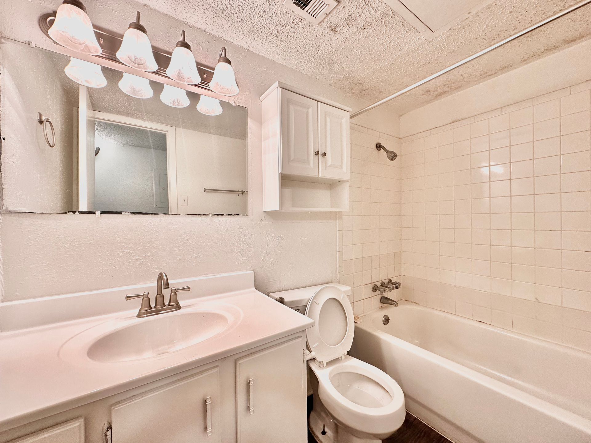A bathroom with a toilet , sink and bathtub.