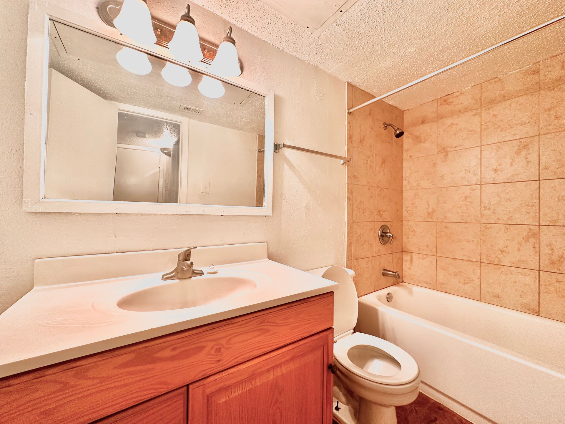 A bathroom with a sink , toilet , bathtub and mirror.