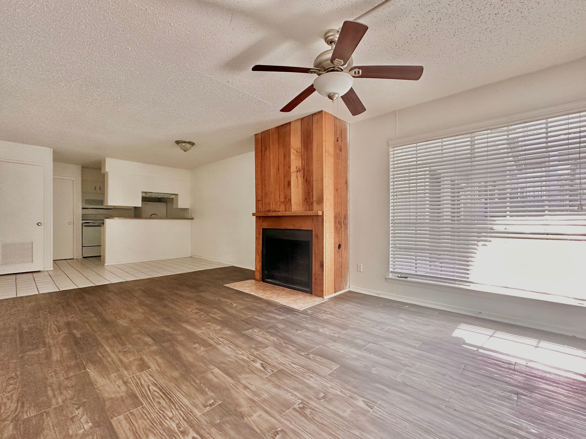 A living room with a fireplace and a ceiling fan