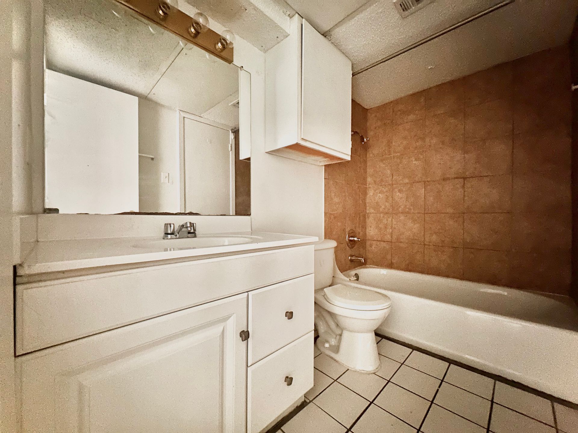 A bathroom with a toilet , sink and bathtub