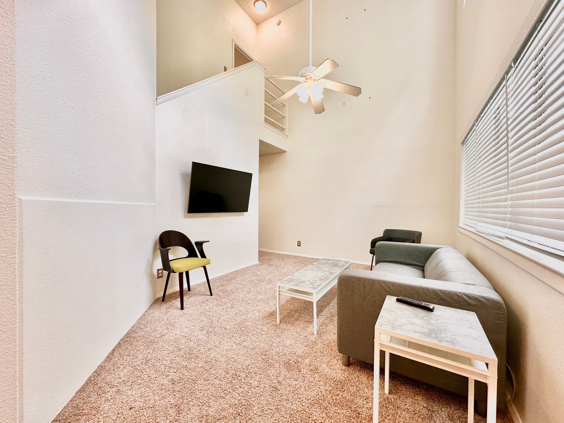 A living room with a couch , chair , table and television.