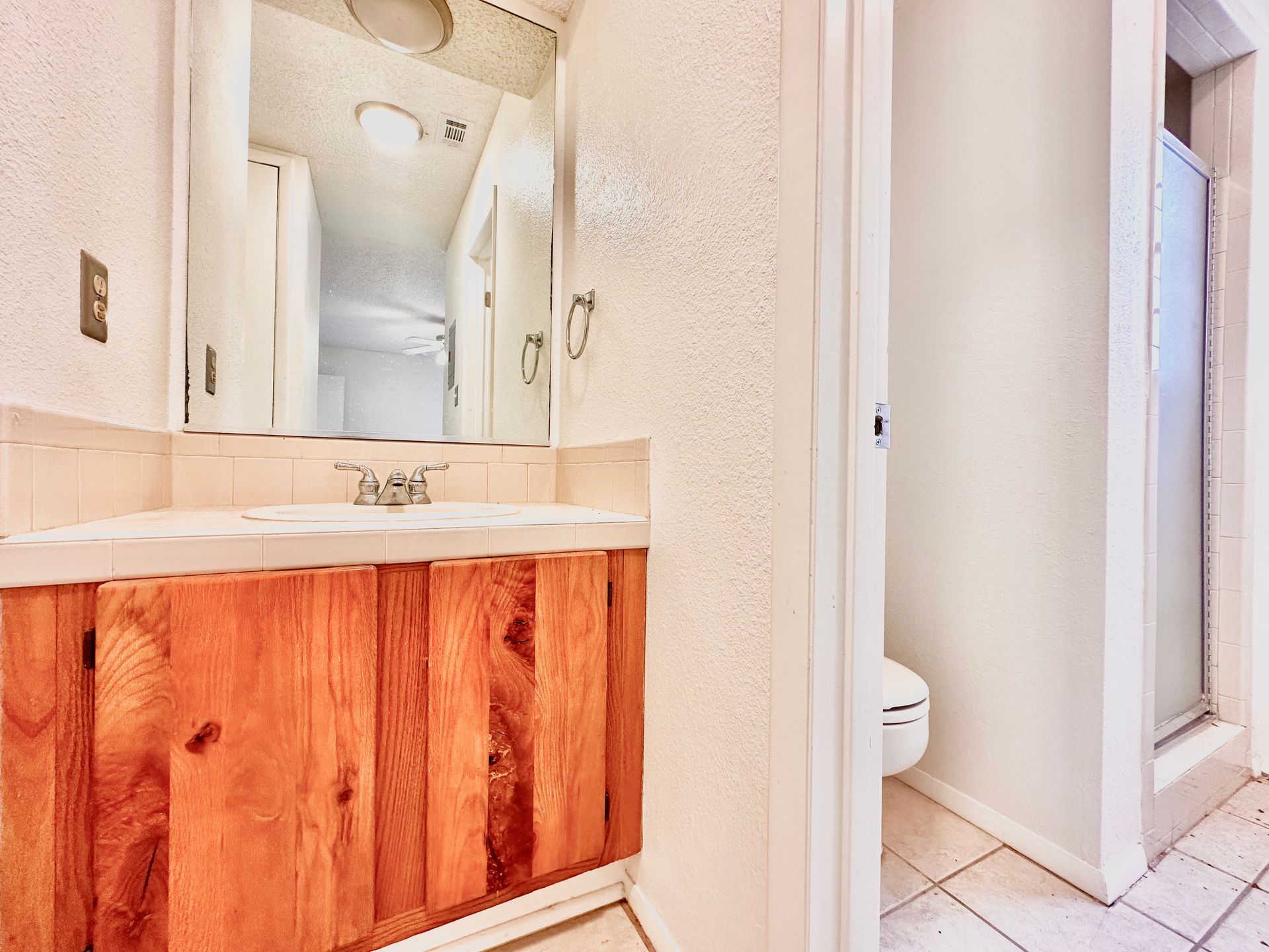 A bathroom with a sink , mirror and toilet.
