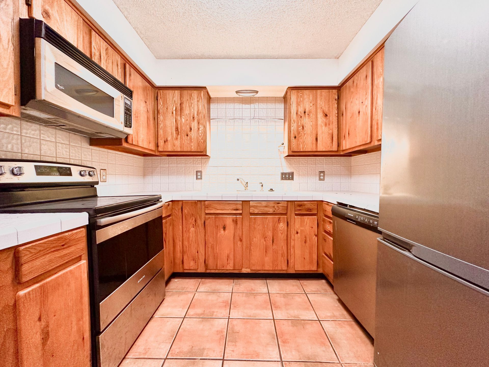 A kitchen with wooden cabinets and stainless steel appliances