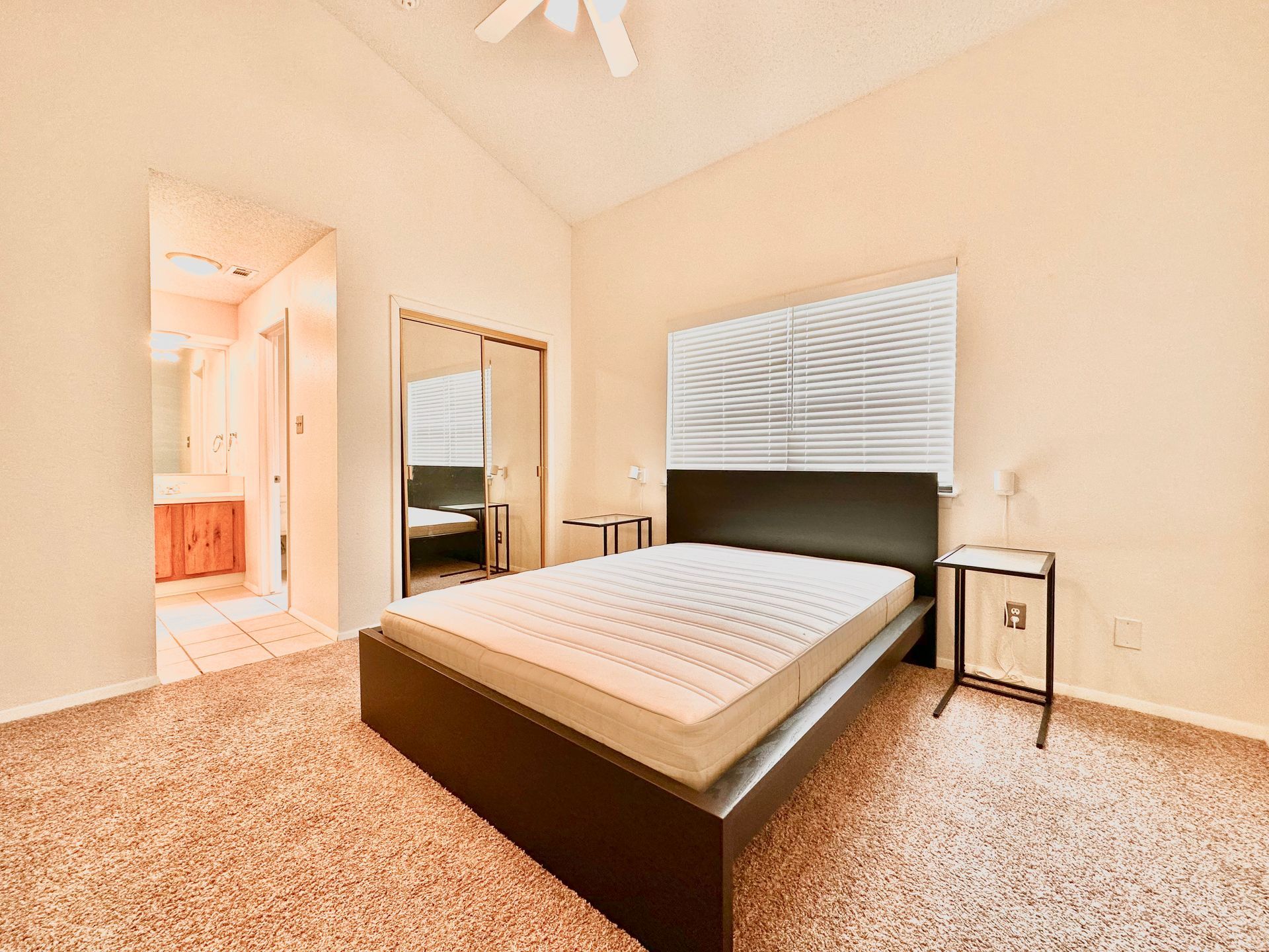 A bedroom with a king size bed and a ceiling fan.