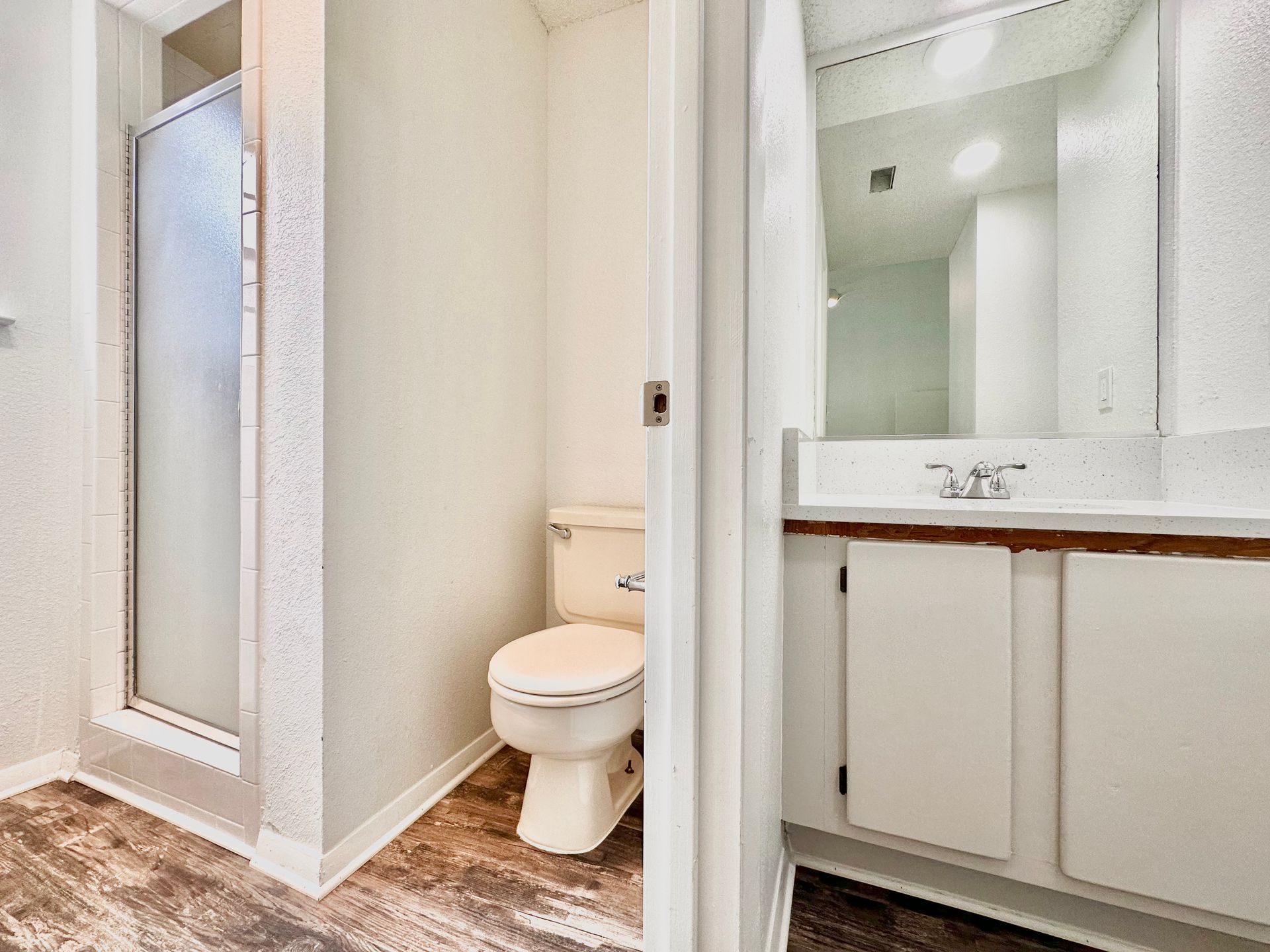 A bathroom with a toilet , sink and shower.