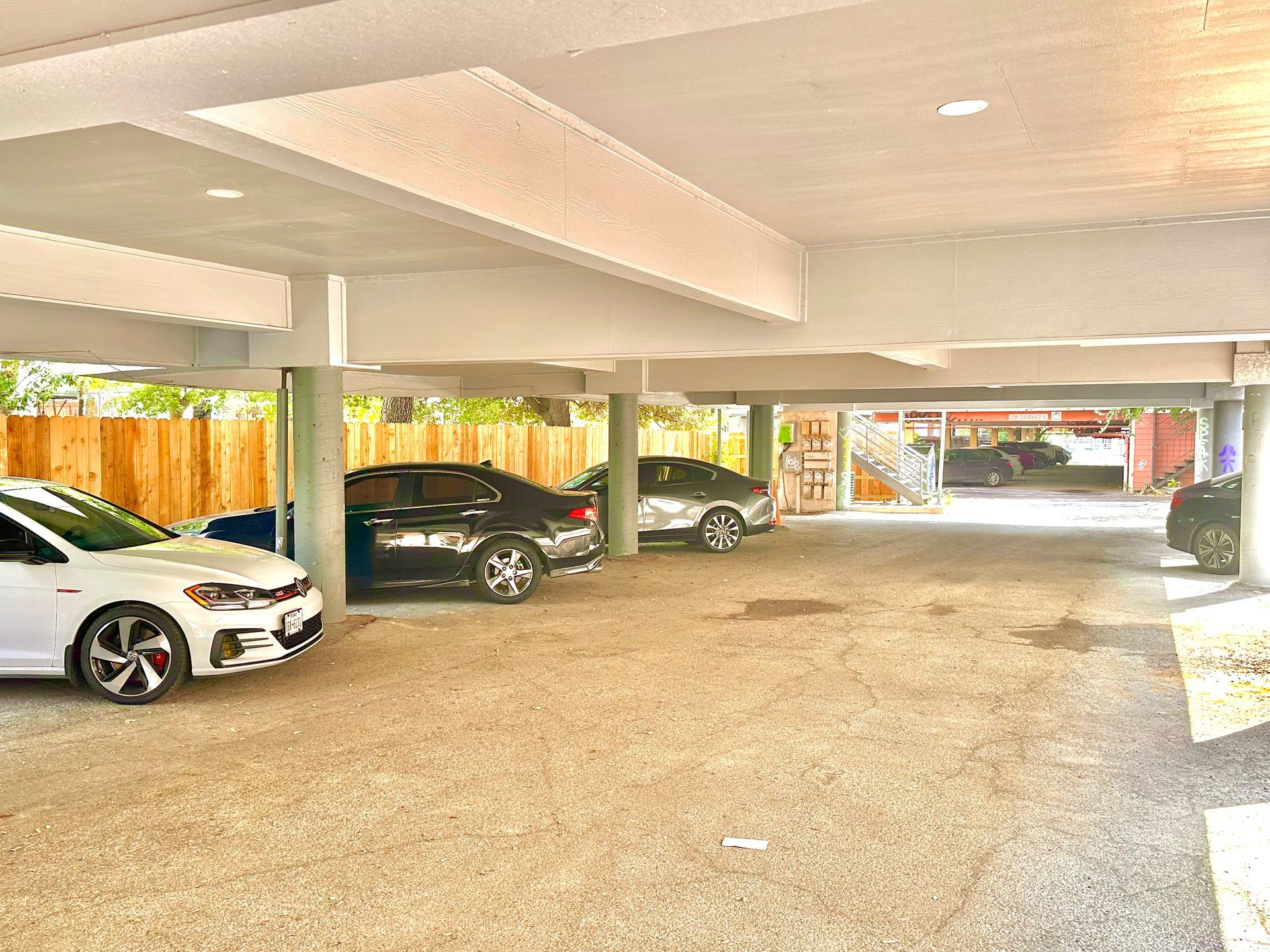 A parking garage with cars parked underneath a building.