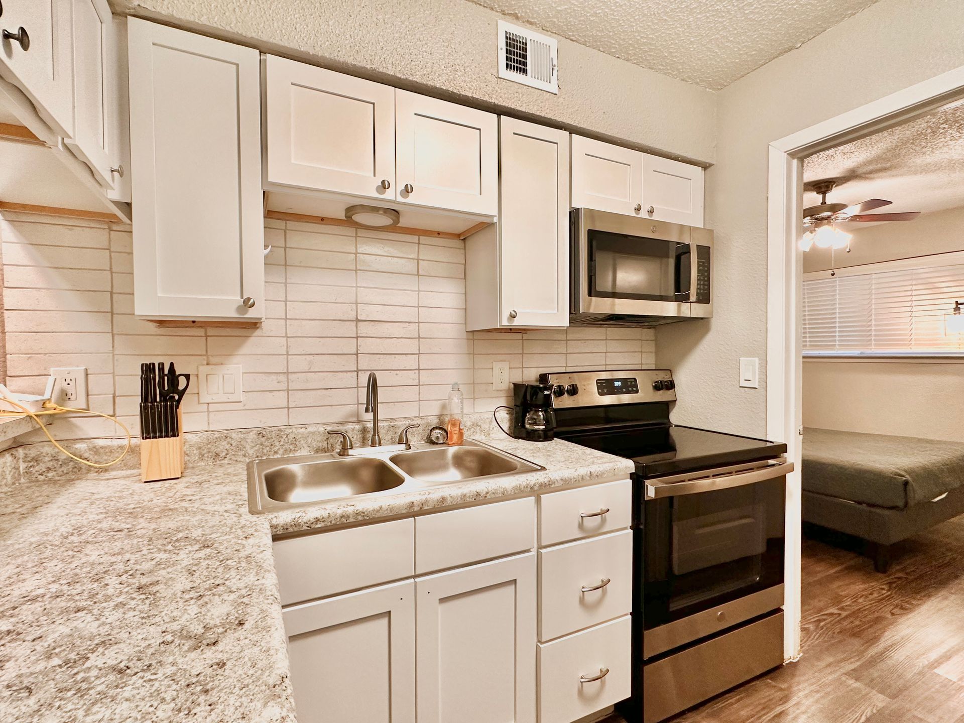 A kitchen with stainless steel appliances and granite counter tops.