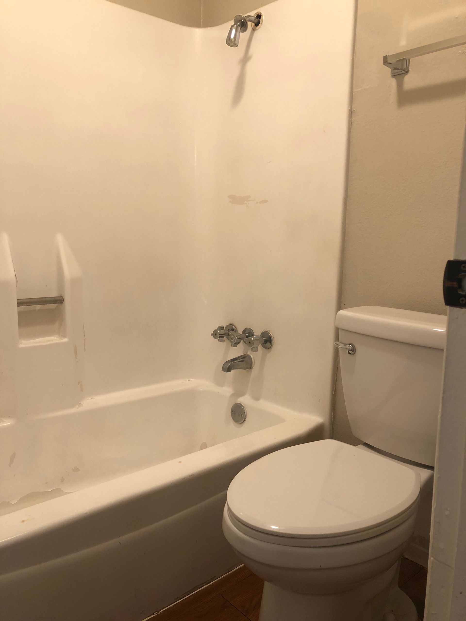 A bathroom with a toilet , bathtub and shower.