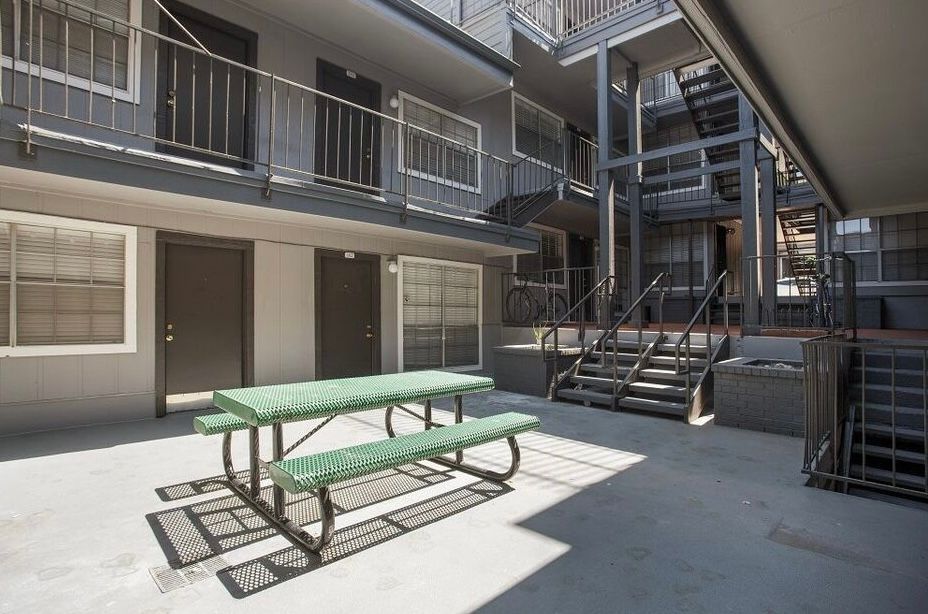 There is a picnic table in the middle of the courtyard of a building.