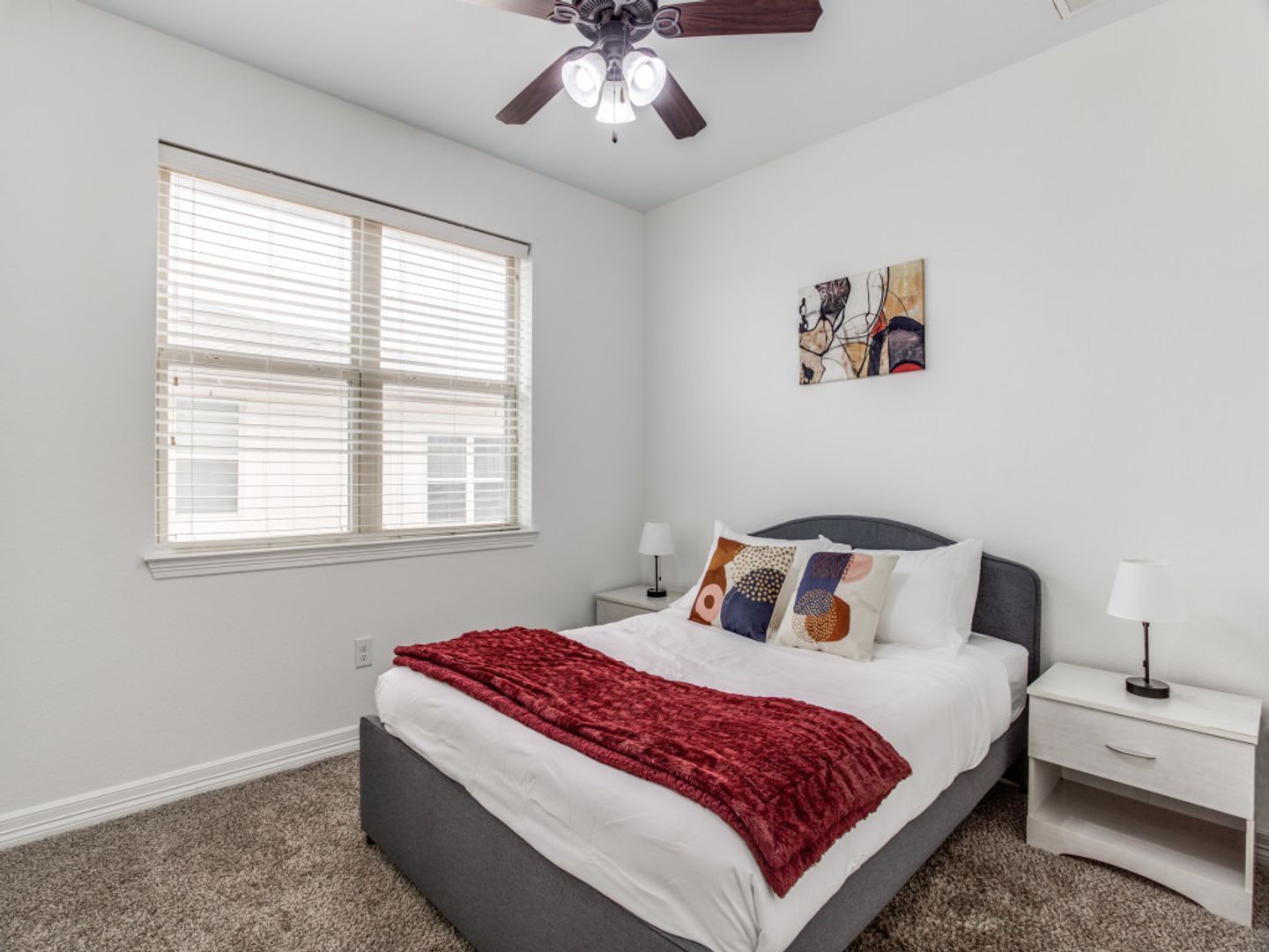 A bedroom with a bed , nightstands , and a ceiling fan.