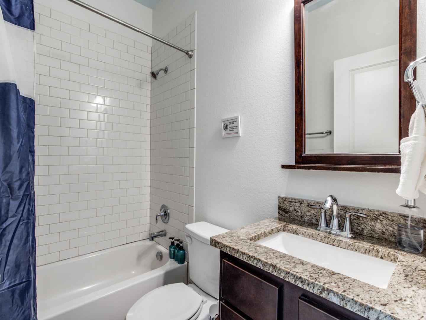 A bathroom with a toilet , sink , bathtub and mirror.