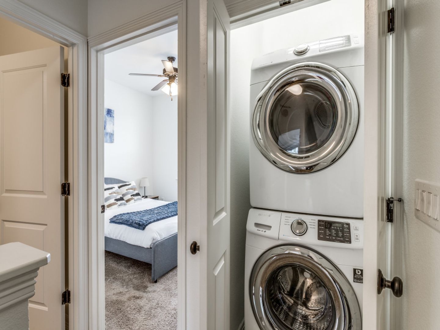 A washer and dryer are stacked on top of each other in a laundry room.