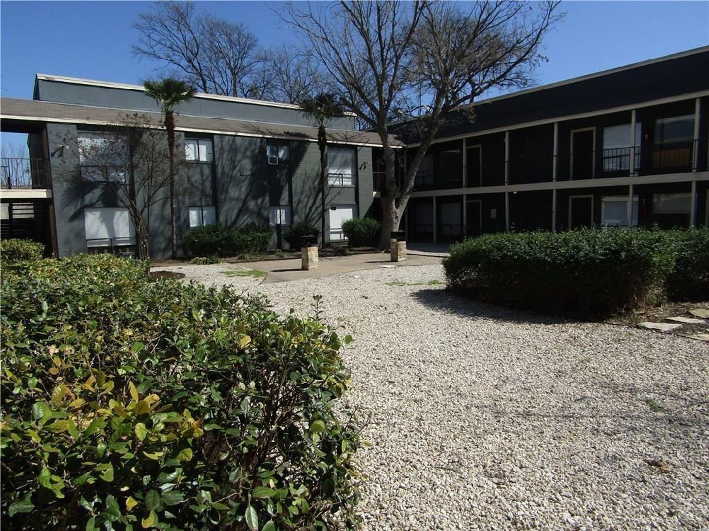A building with a gravel driveway in front of it
