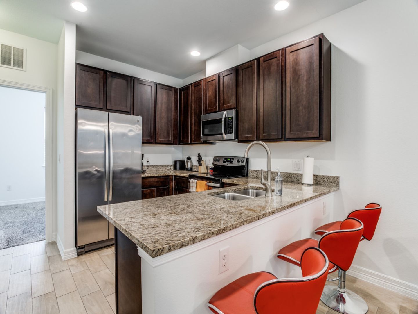 A kitchen with stainless steel appliances and granite counter tops.