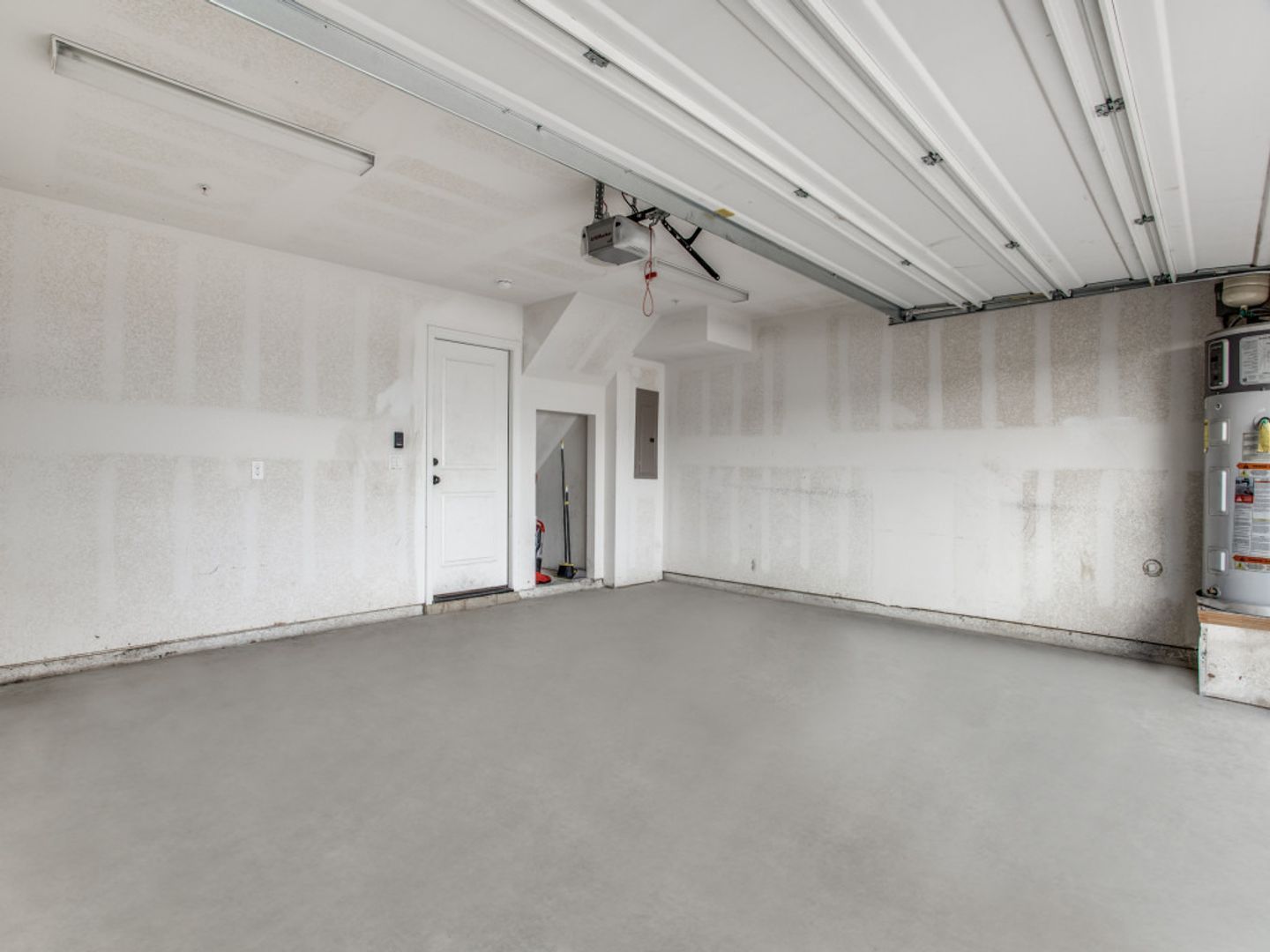An empty garage with white walls and a gray floor.