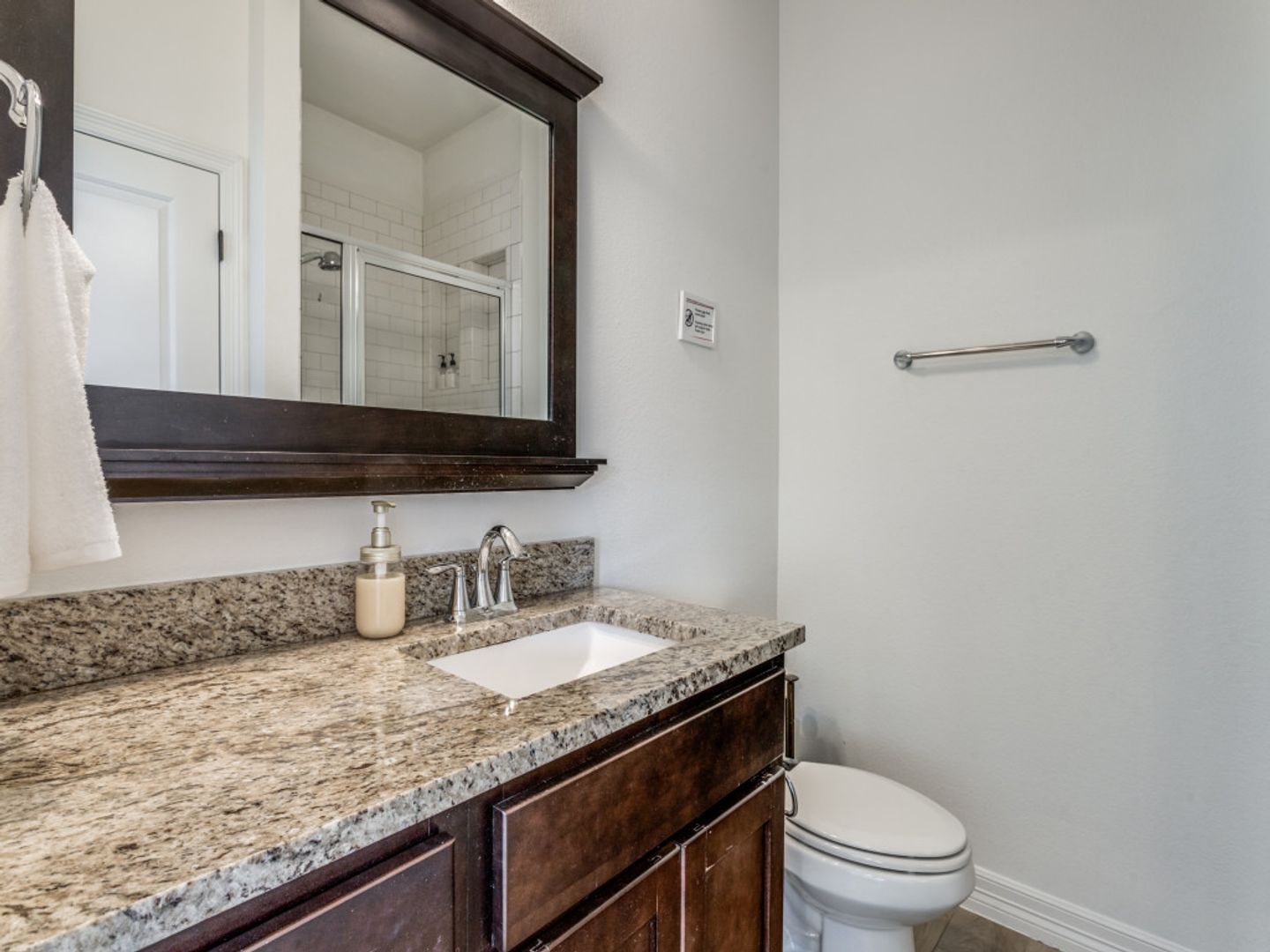 A bathroom with a sink , toilet and mirror.