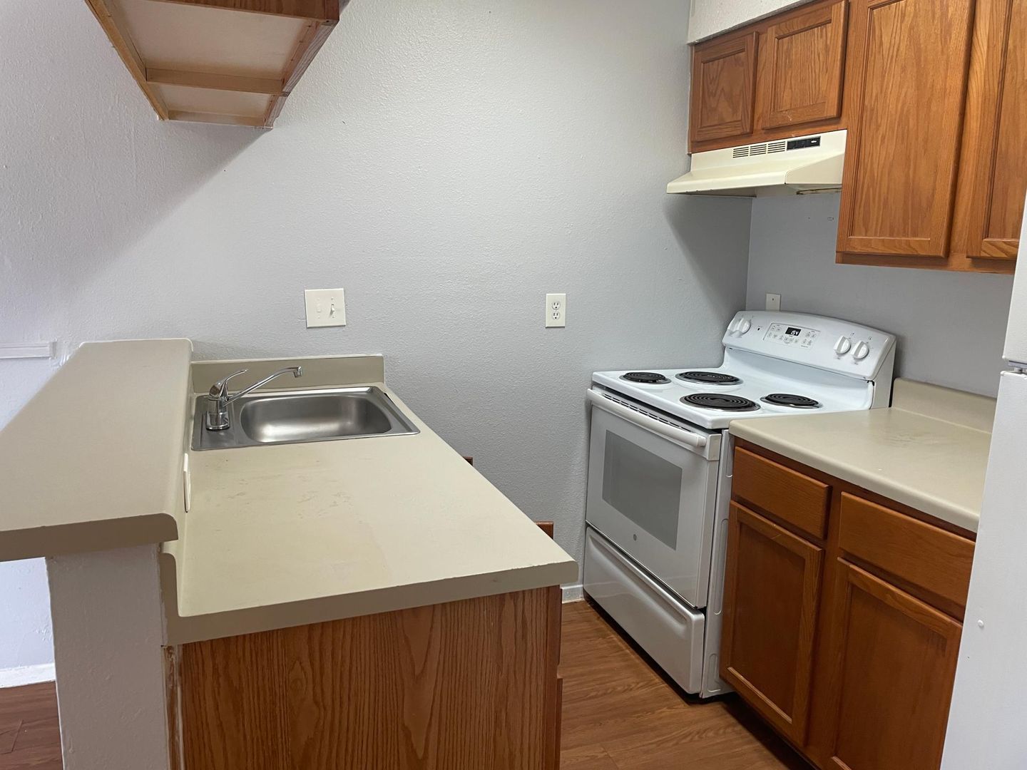 A kitchen with a stove , sink , and refrigerator.