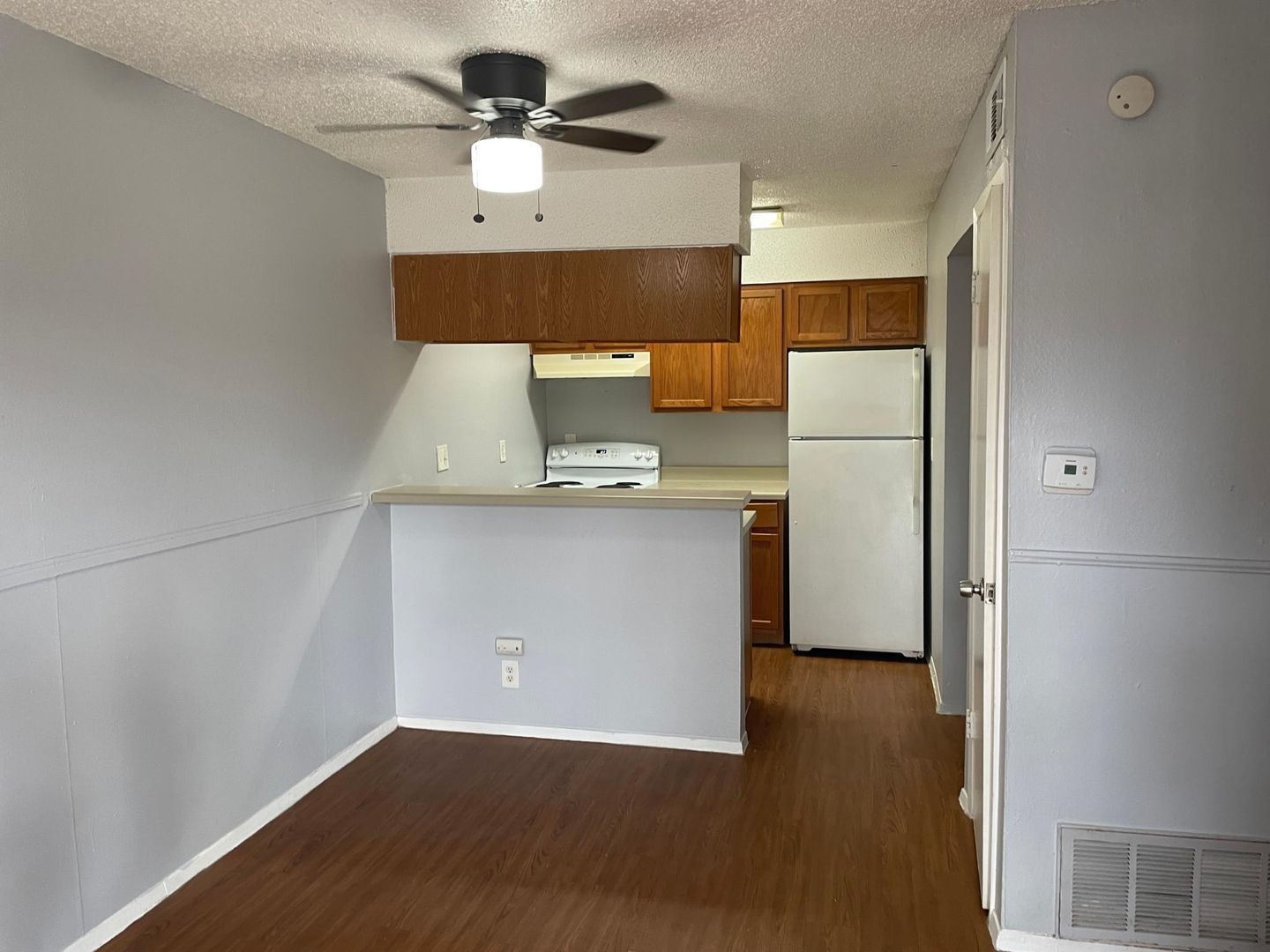 A kitchen with a ceiling fan and a refrigerator