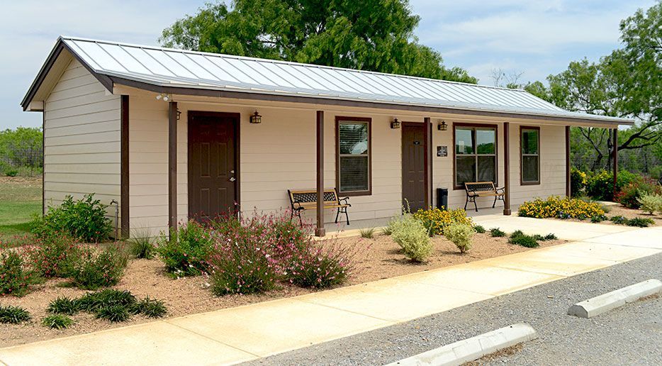 A small white house with a metal roof and a porch
