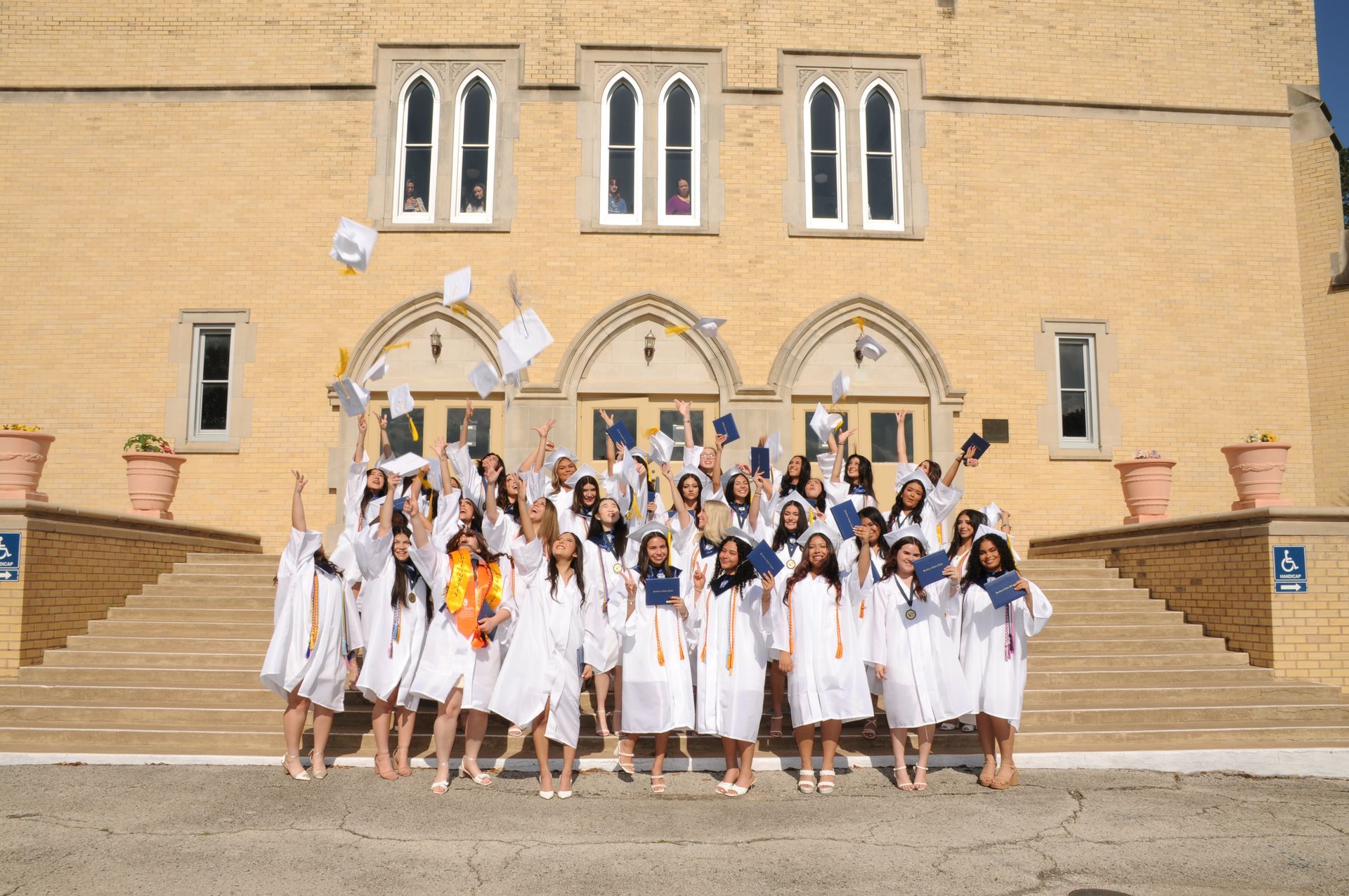 A group of graduates are throwing their caps in the air.