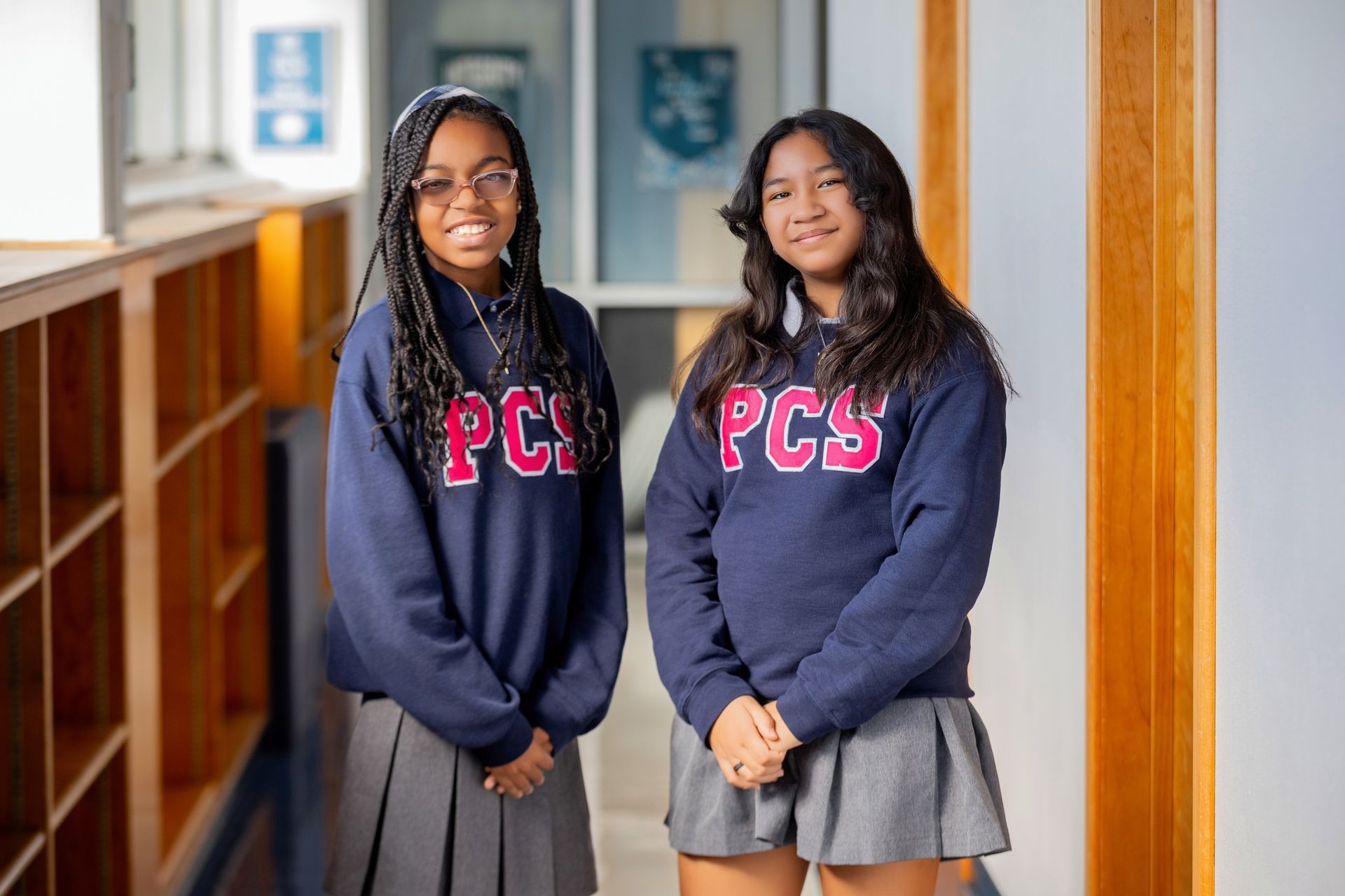 A group of girls are standing next to each other in front of a sign that says sisterhood.