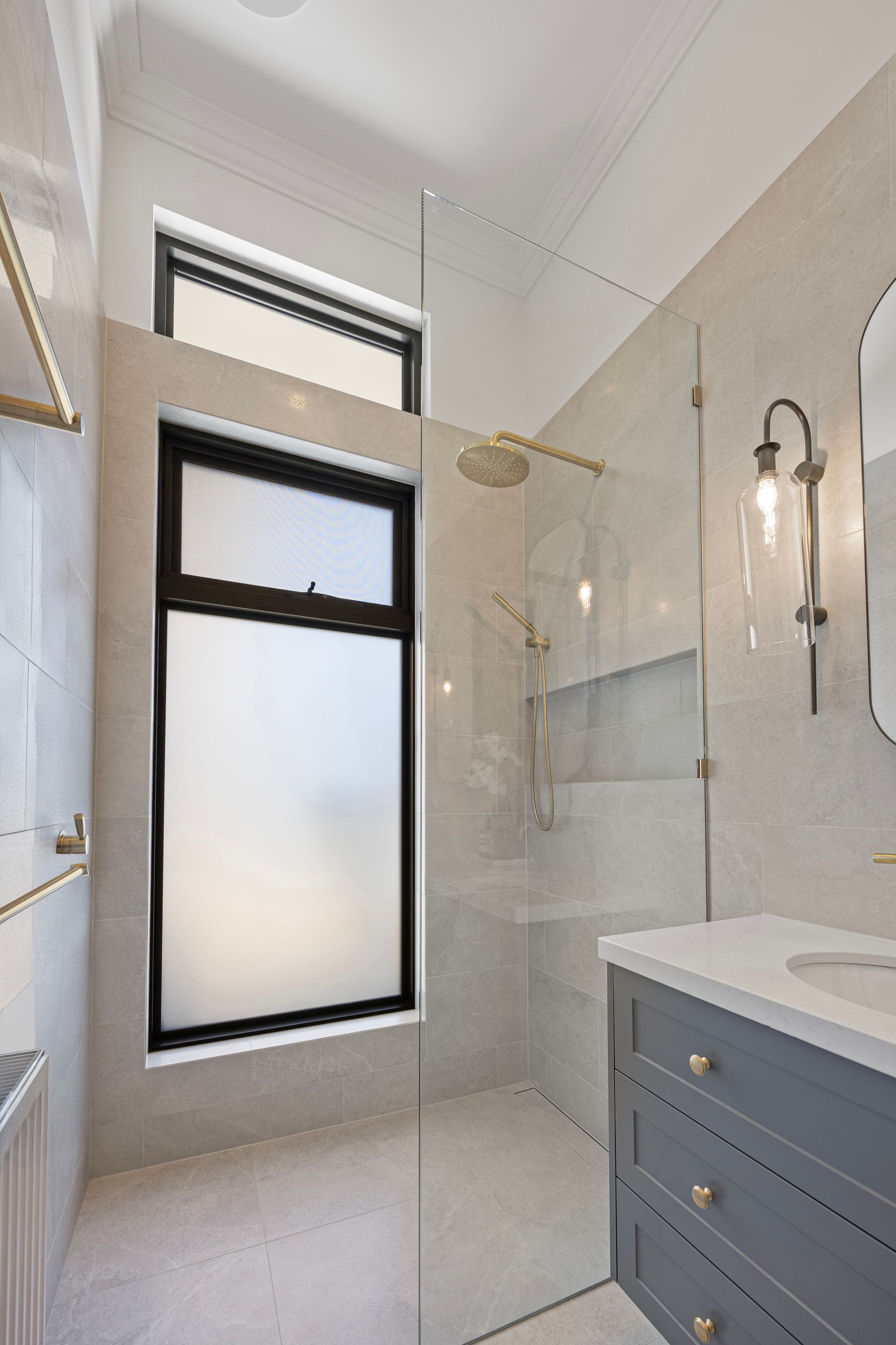 Powder room with curved mirror and natural finishes