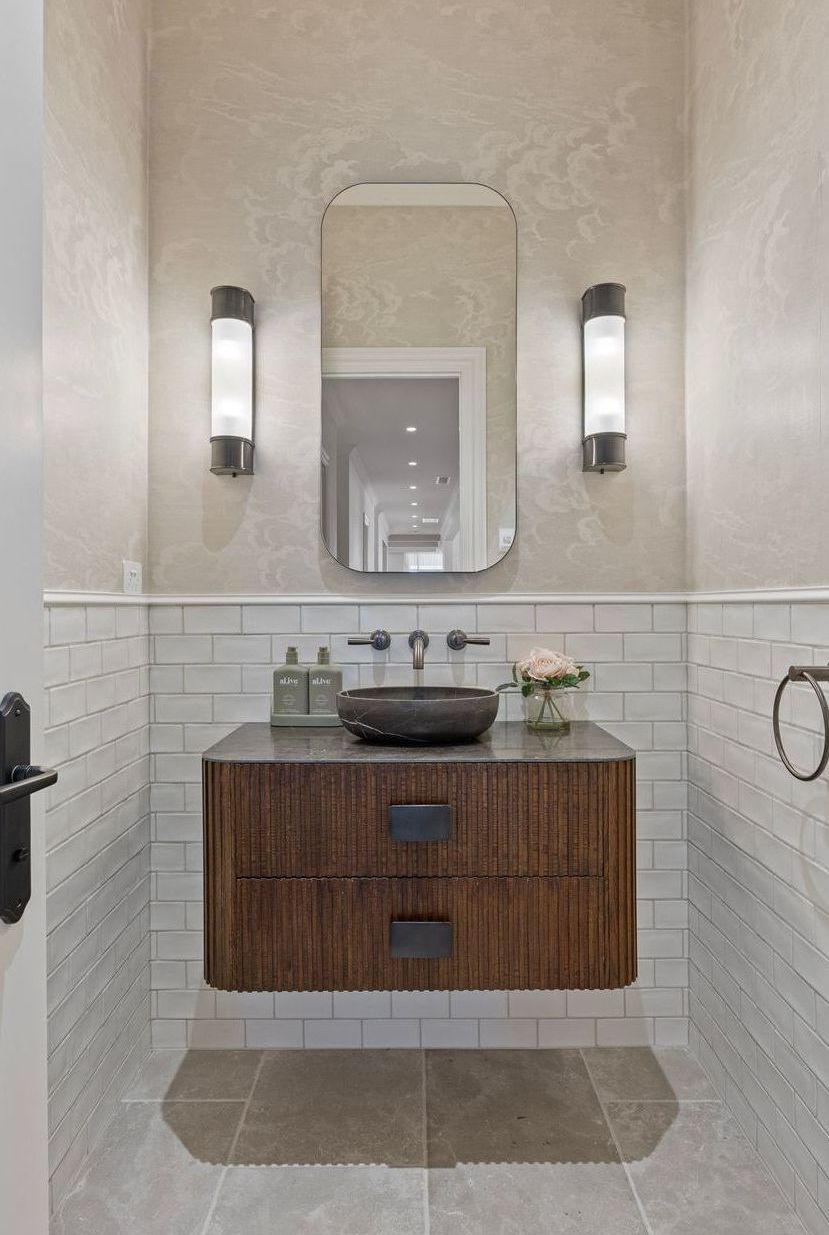 Powder room with curved mirror and natural finishes