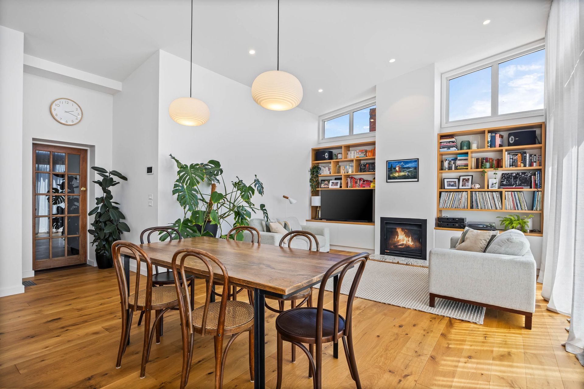  Open-plan dining and living space with hardwood floors and integrated joinery.