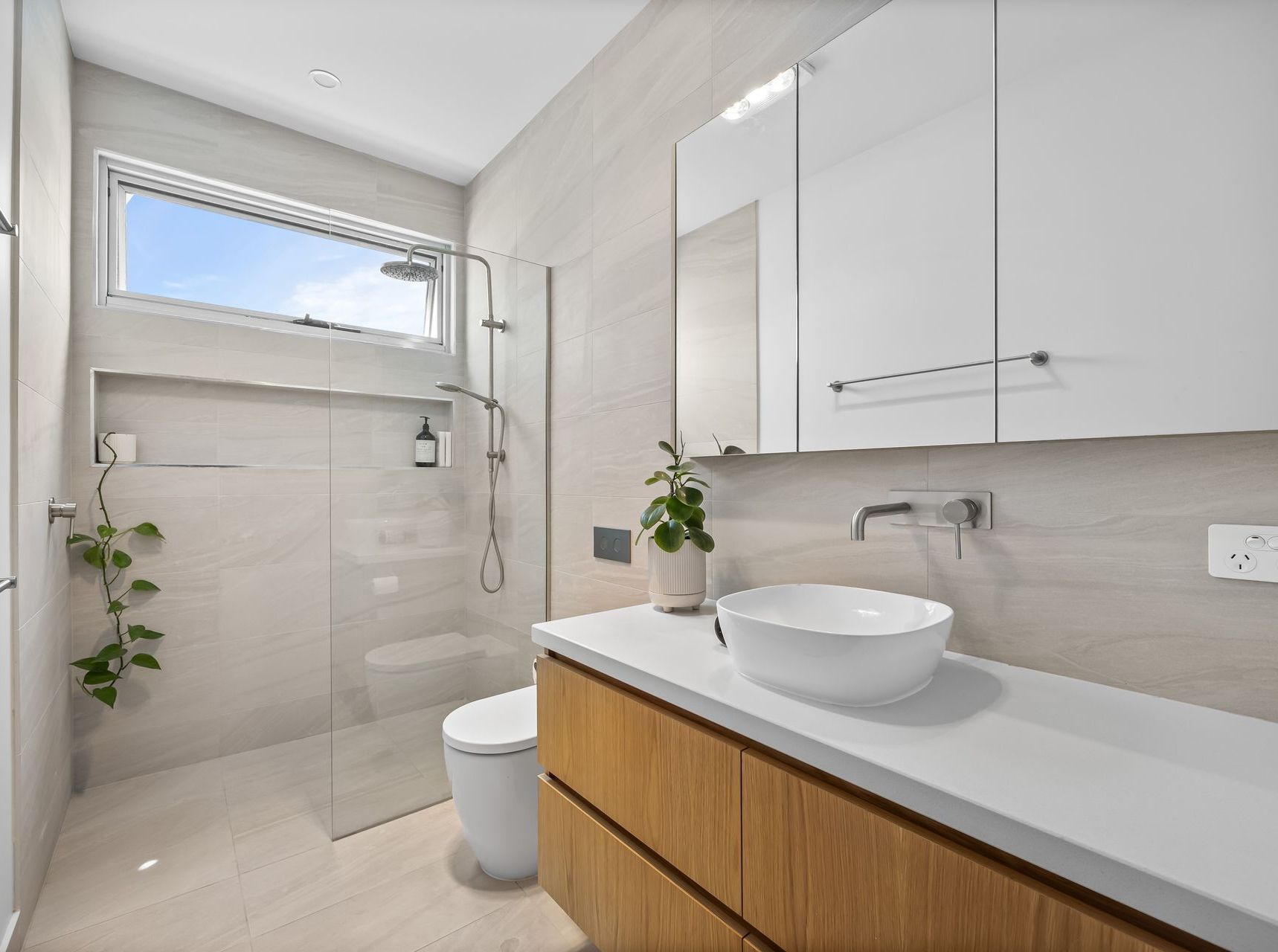 Contemporary bathroom with frameless shower, floating vanity and wall tile finish.
