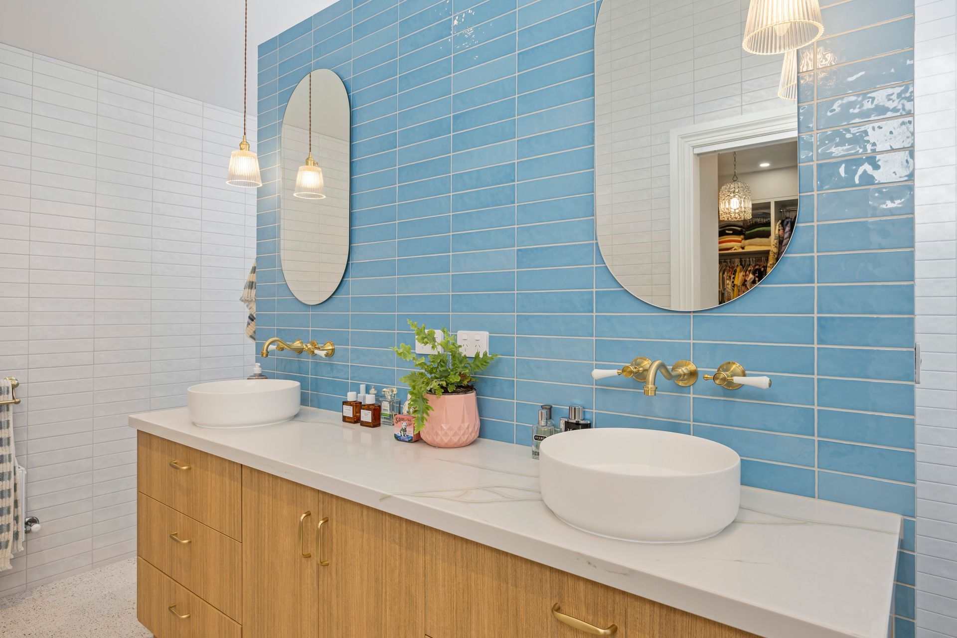 Blue tiled bathroom with twin mirrors and timber vanity