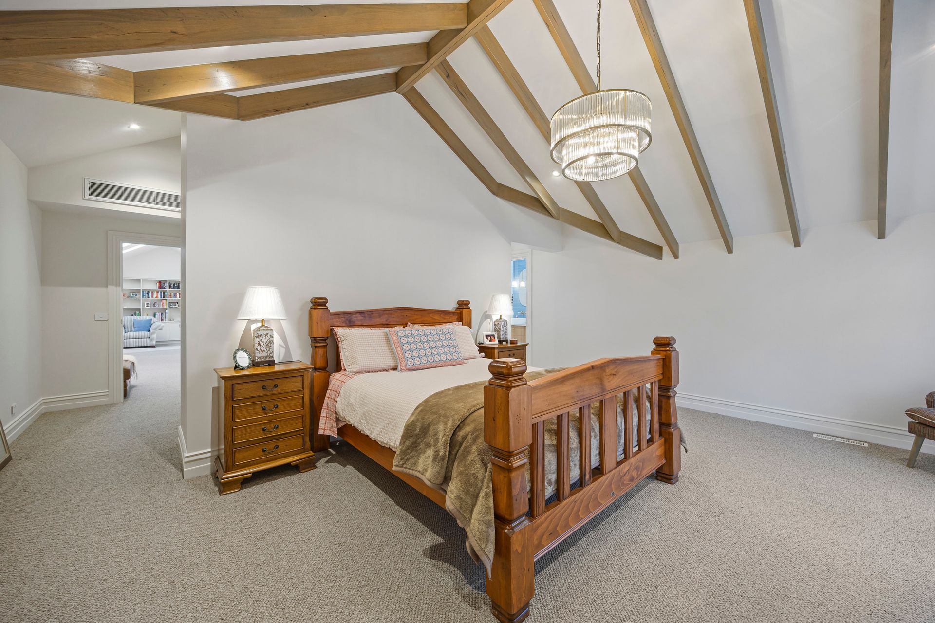 bedroom with timber ceiling beams and chandelier