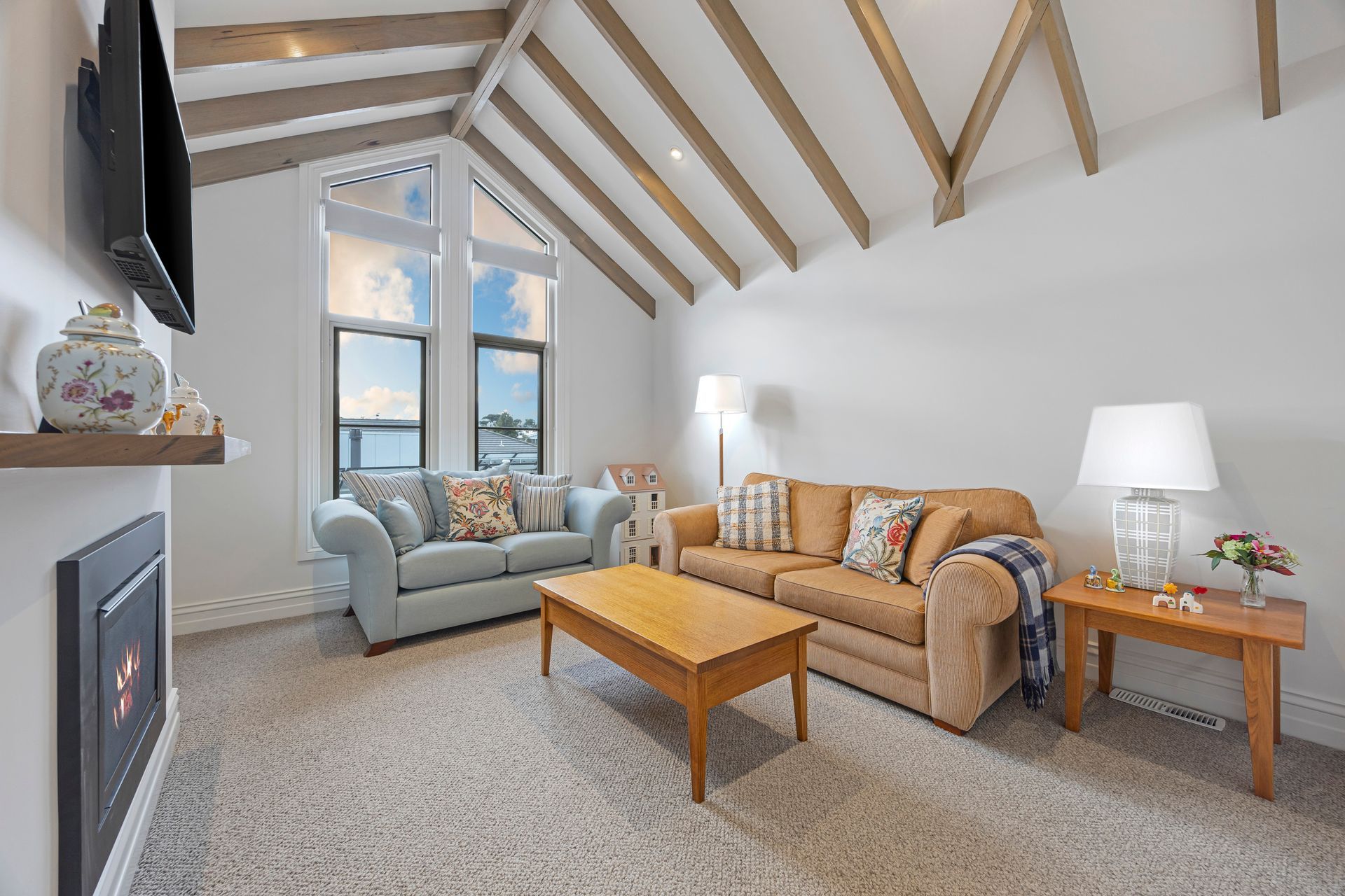 Lounge area with vaulted ceiling, timber beams and fireplace