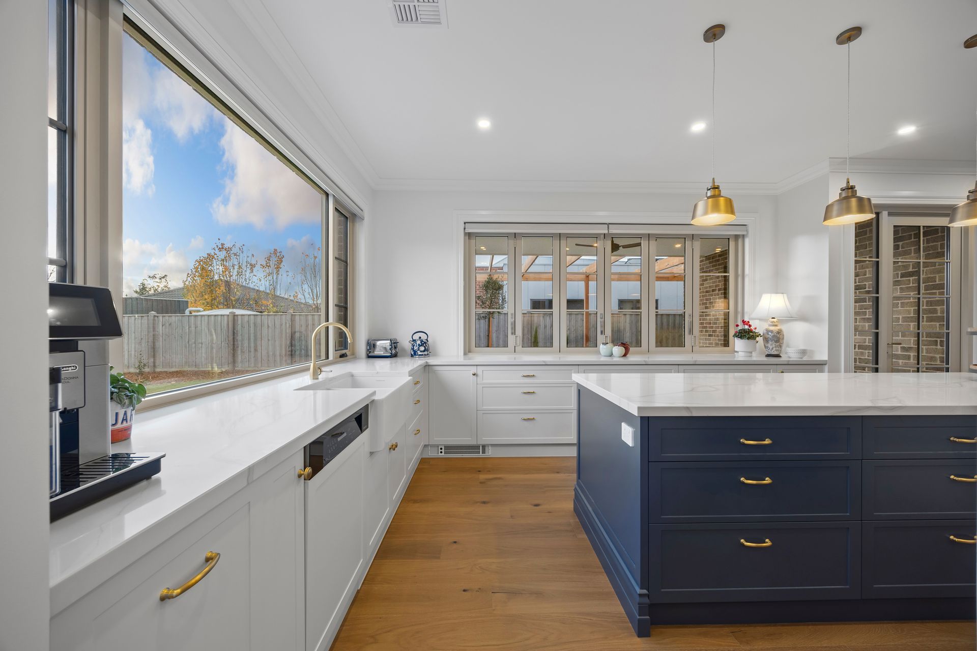 Kitchen island and large window with leafy views