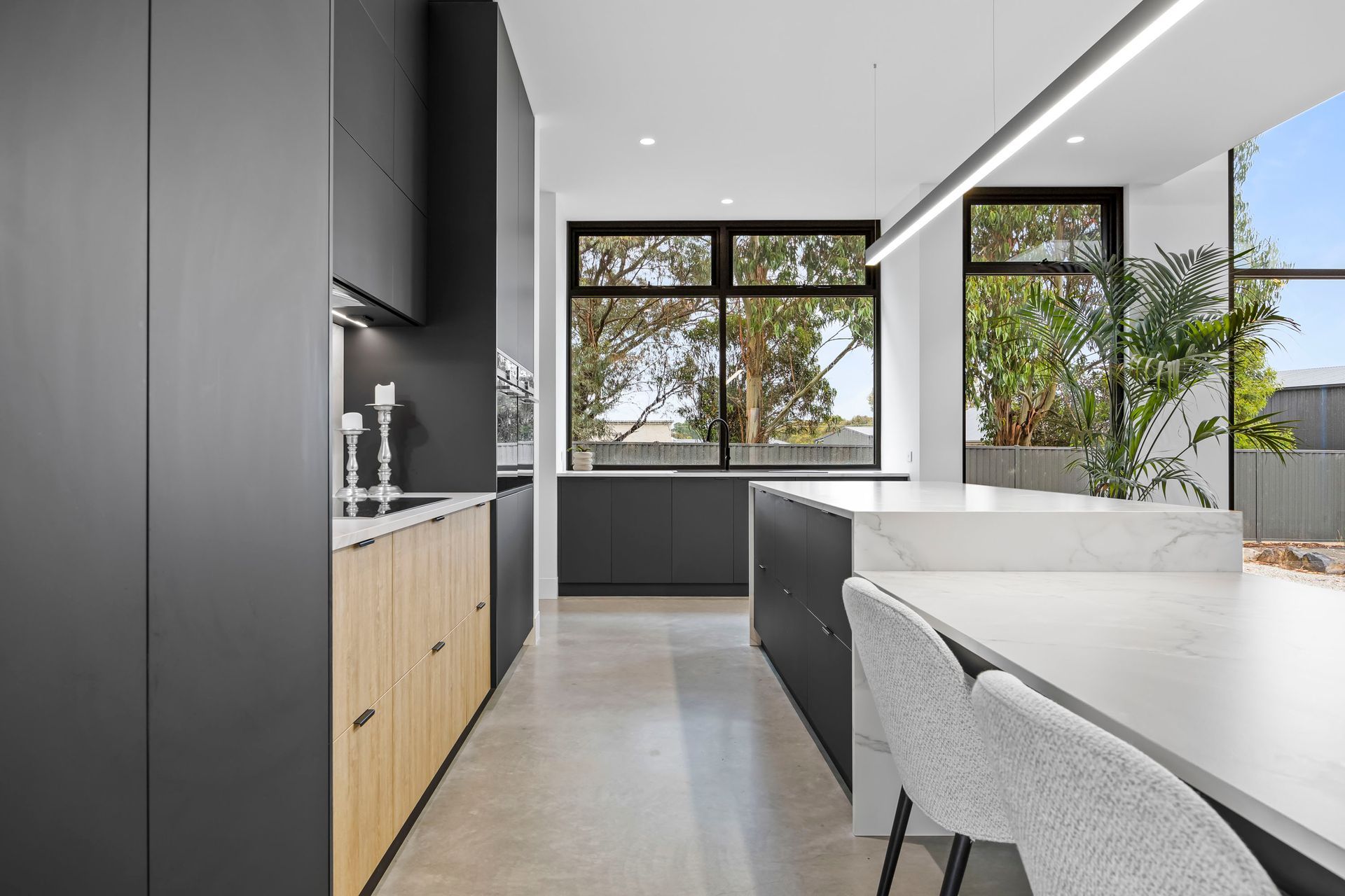 Elegant kitchen layout with matte black cabinetry and open living views.
