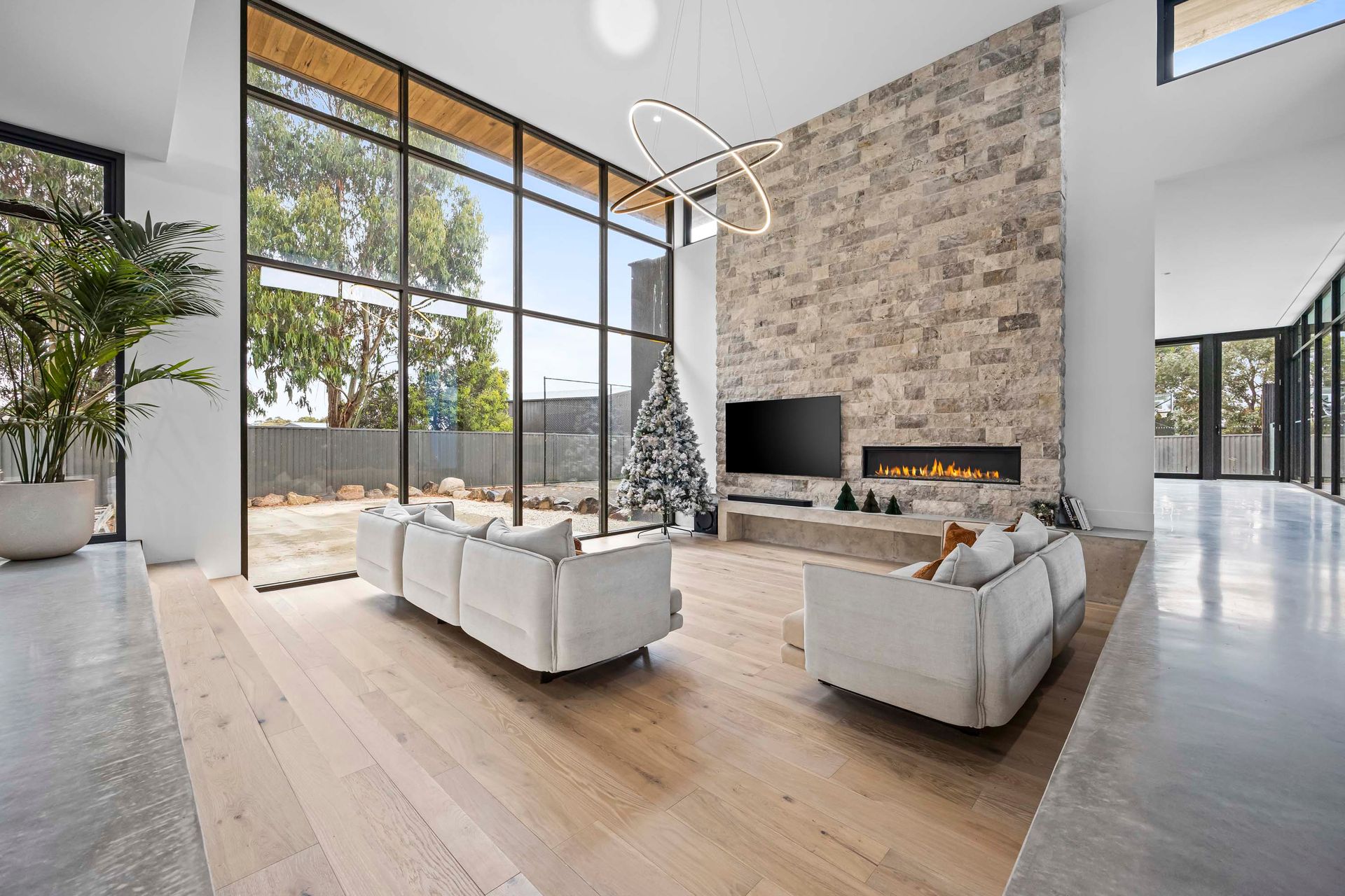 Spacious open-plan living with double-height windows.
