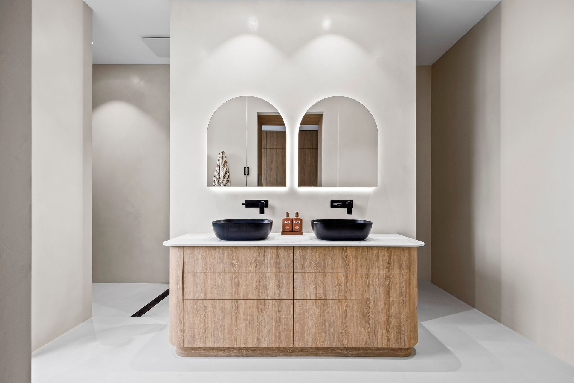Ensuite with dual basins, curved mirrors, and timber vanity.