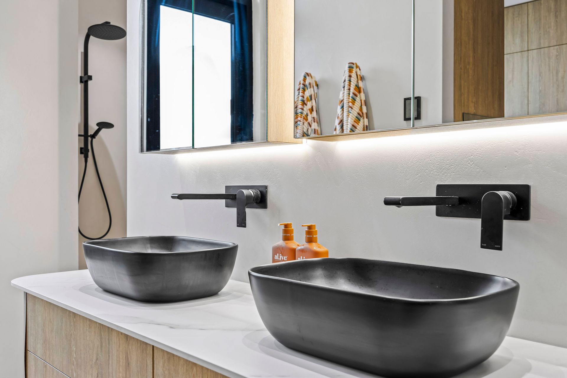 Modern ensuite with matte black basins and tapware.