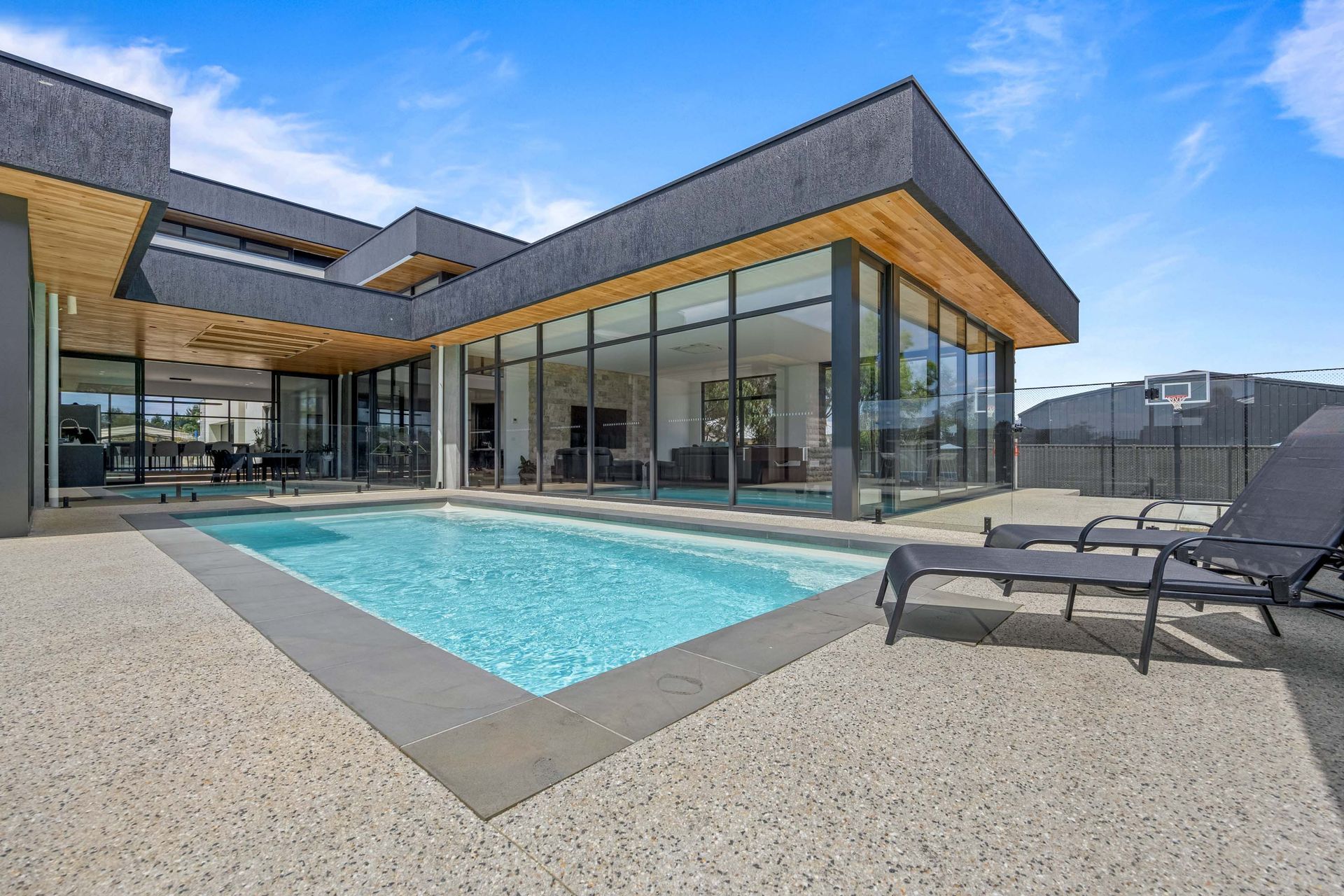 Contemporary home exterior with sleek architectural lines and a luxurious poolside entertaining area.