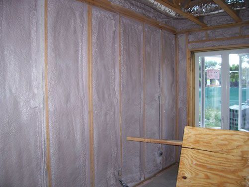 Insulated unfinished room with foil wall wrap, exposed framing, and a window.