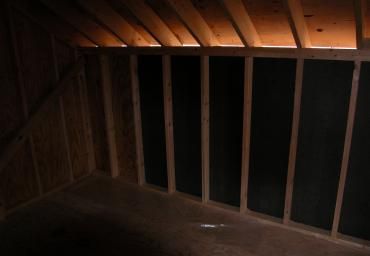 Dim wooden stairwell or attic opening with vertical rail slats in low light