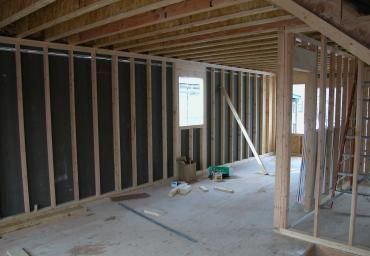 Interior of a house under construction with exposed wood framing and unfinished walls
