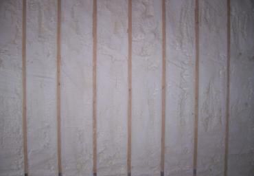 Close-up of a white wall with vertical beige and pinkish streaks and texture