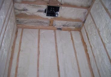 Insulated attic walls and ceiling framing with a small vent opening overhead