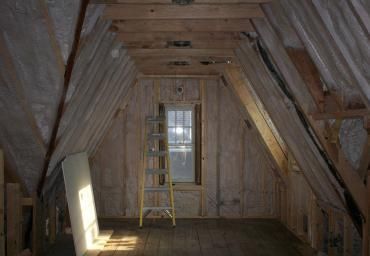 Attic room with exposed wooden beams, a ladder, and a window