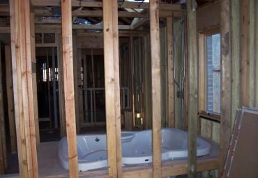 Partially framed bathroom with a built-in bathtub and exposed wooden studs