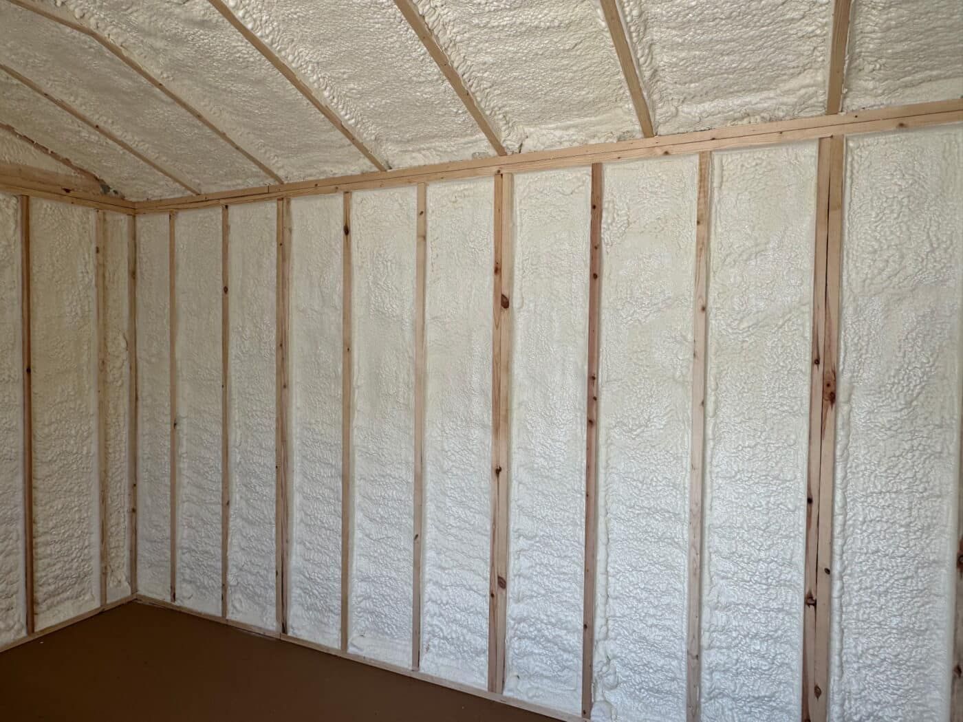 Insulated unfinished room with exposed wooden studs and white spray-foam walls and ceiling