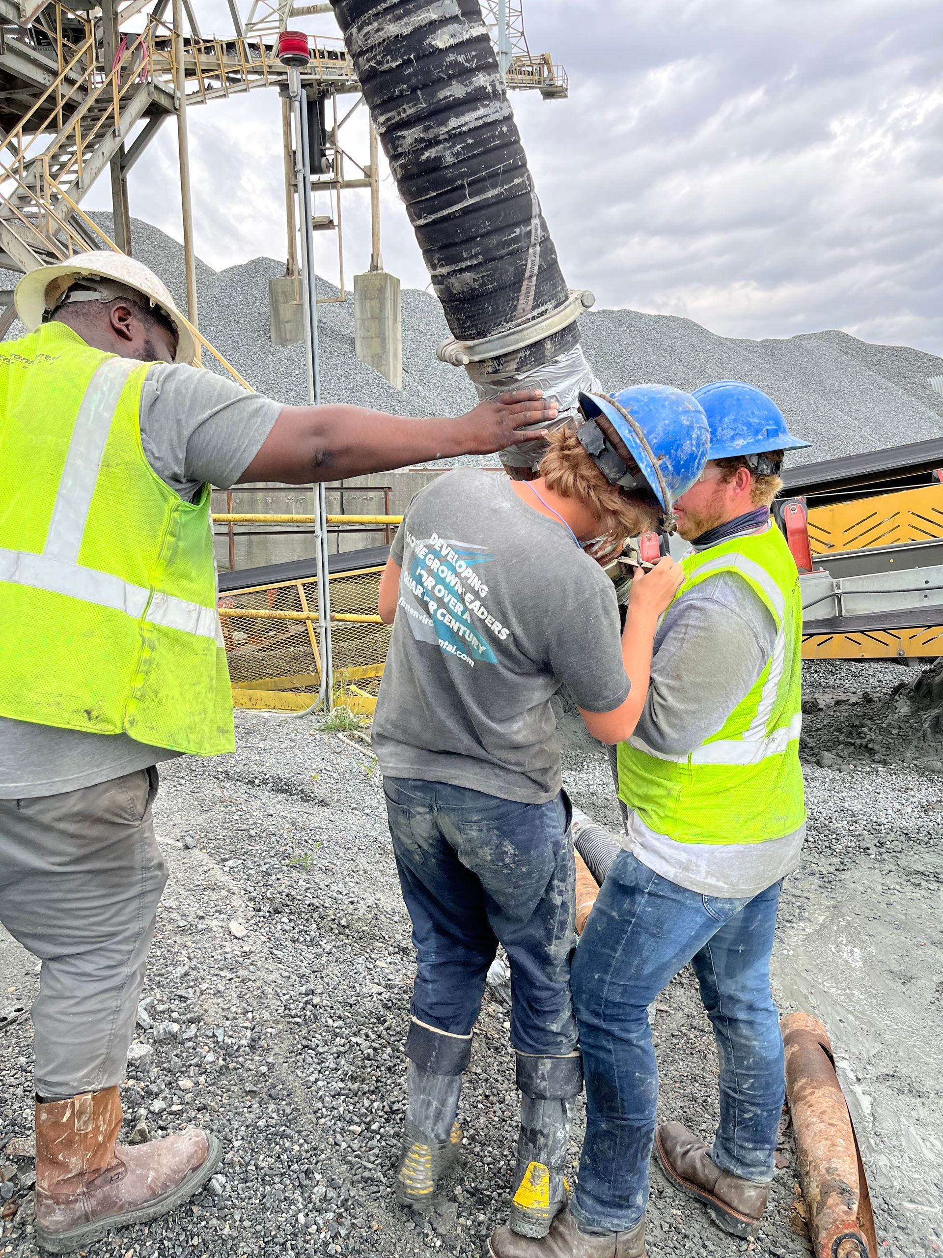 A group of construction workers are working on a pipe.