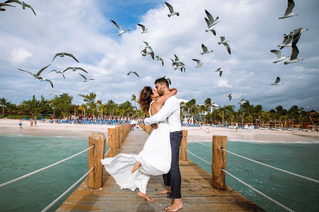 Couple kissing by the ocean.