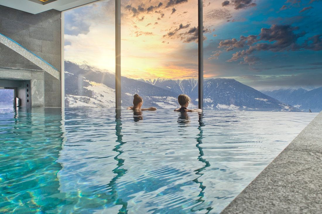 Couple looking at a window from an infinity pool.