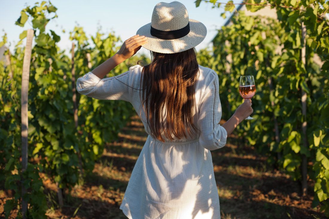 Woman walking through a vineyard.